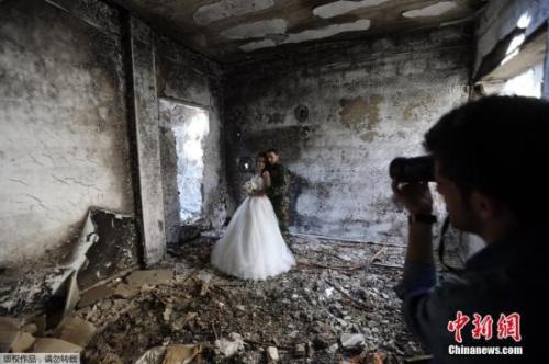 叙利亚霍姆斯一对新婚夫妇以饱受战争蹂躏被毁的建筑为背景拍摄了婚纱照。 叙利亚霍姆斯一对新婚夫妇以饱受战争蹂躏被毁的建筑为背景拍摄了婚纱照。